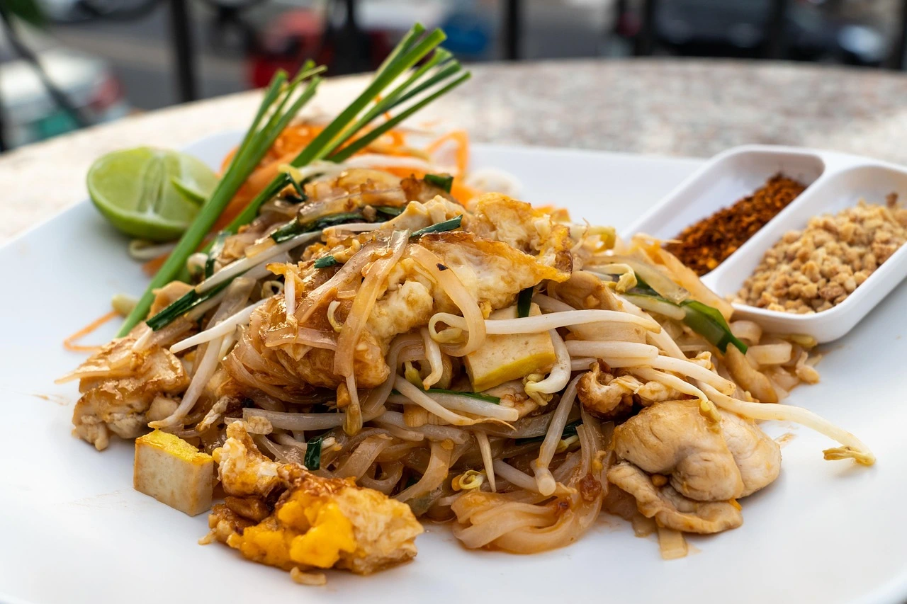 Authentic Pad Thai with shrimp, egg, peanuts and lime served at a Thailand street food market